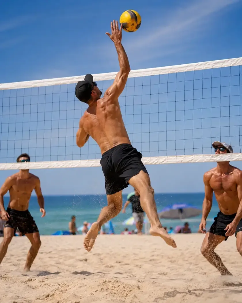 Atleta atacando em partida de vôlei de praia